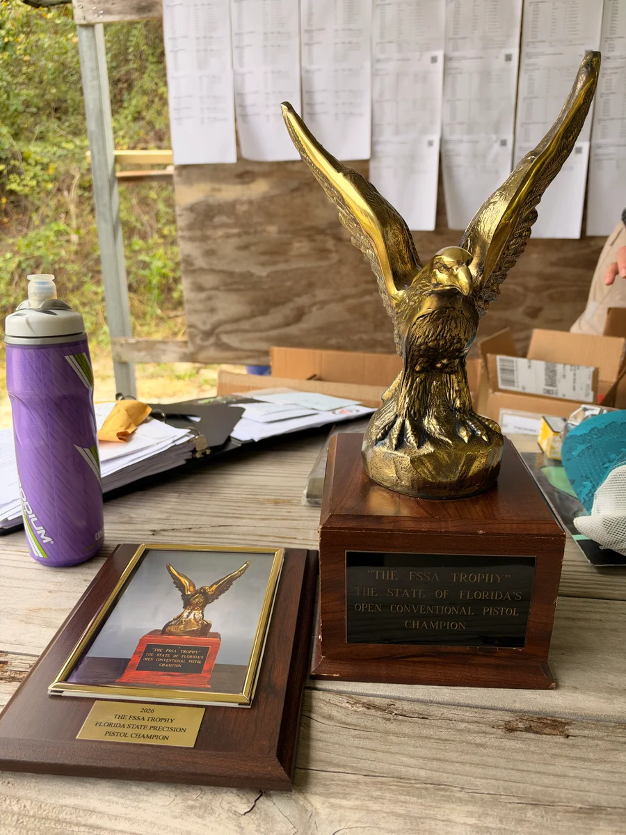 The Florida State Shooting Association trophy and 2026 Florida State Precision Pistol Champion plaque.